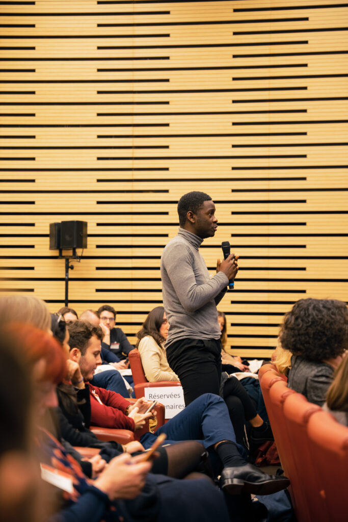 Photo d'un homme posant une question lors d'une assemblée