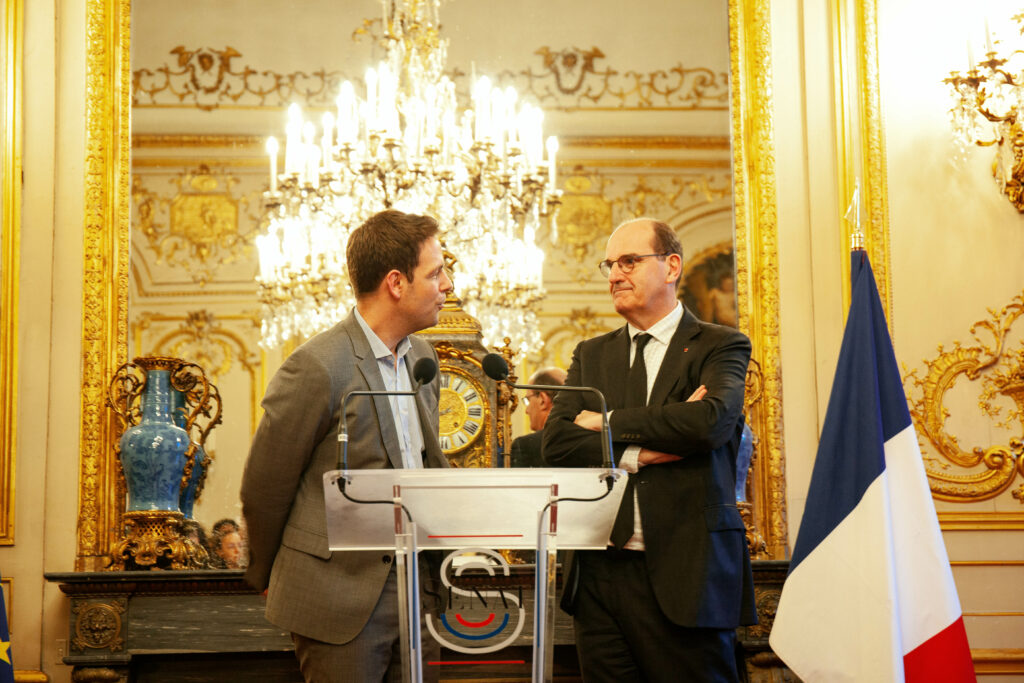Jean Castex et Damien Zaversnik à une tribune du Sénat. On peut voir le drapeau français à droite.